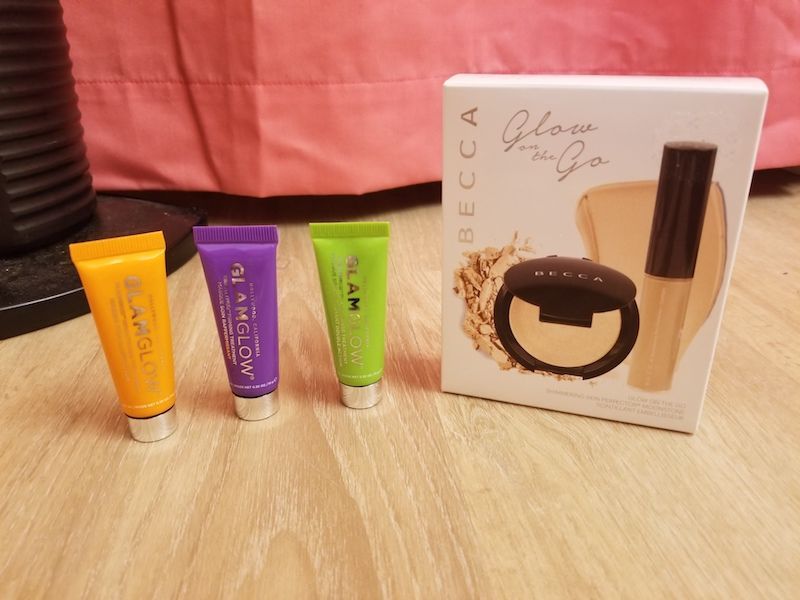 Three super cute Glamglow tubes (Flashmud Brightening Treatment, Gravitymud Firming Treatment, and Powermud Dual Cleansing Treatment) next to a Becca Glow on the Go Kit (including Shimmering Skin Perfector Spotlight in Moonstone [liquid] and Shimmer Skin Perfector Pressed in Moonstone)!