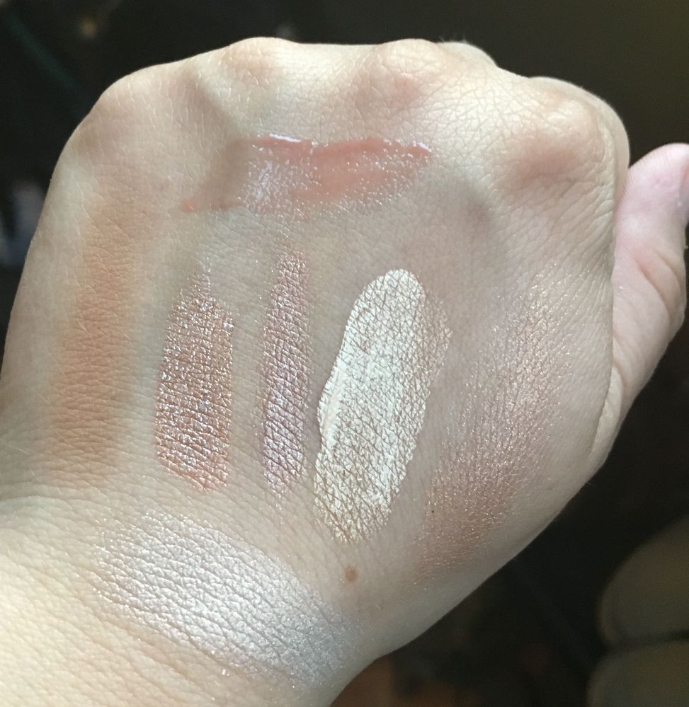 From far left: Fenty Beauty bronzer in Shady Biz, Tarte Seaglass eyeshadow in Suite life, Charlotte Tilbury Colour Chameleon in Champagne Diamonds, Marc Jacobs Dew Drops gel in 50 Dew you?,Artist Couture Diamond Glow powder in Conceited, on the far bottom is Becca's Vanilla Quartz and on the very top is Sephora's Ultrashine lip gel in perfect nude