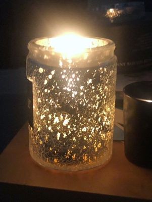 Voluspa candle lit - the jars of either the Gilt Pomander & Hinoki scent or The Holiday Berries scent come in an exquisite jar